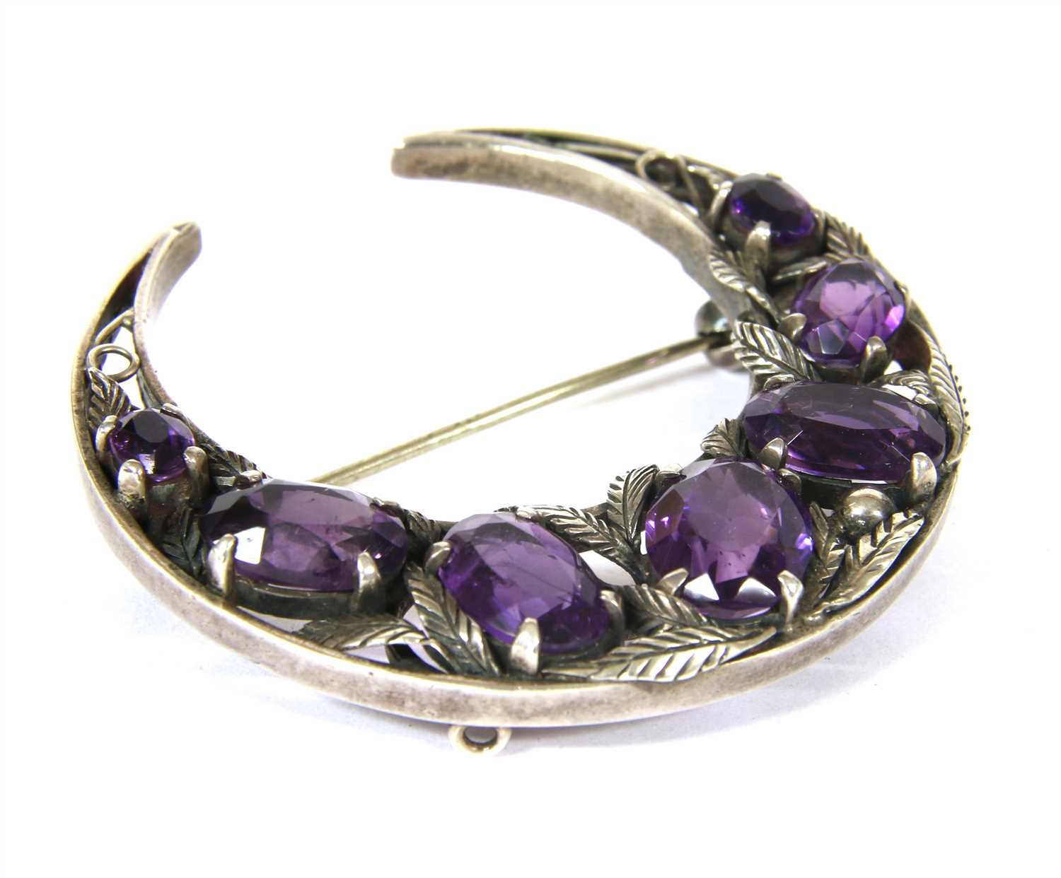 Lot 24 - A silver Arts and Crafts amethyst crescent brooch