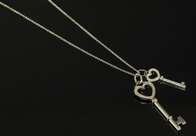 Lot 74 - A platinum and 18ct white gold diamond set heart double key pendant, by Tiffany & Co