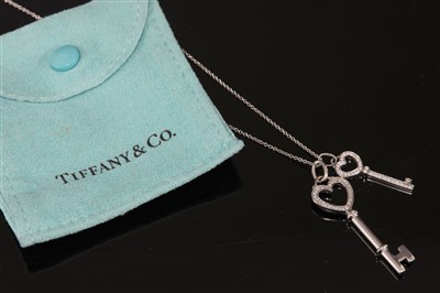 Lot 74 - A platinum and 18ct white gold diamond set heart double key pendant, by Tiffany & Co