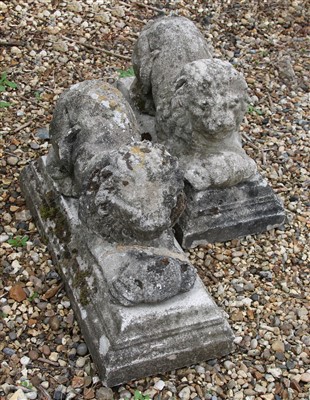 Lot 719 - A pair of reconstituted stone recumbent lions