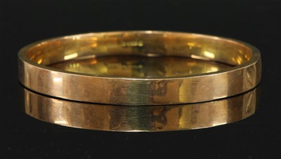 Lot 112 - A 9ct gold flat section hollow slave bangle