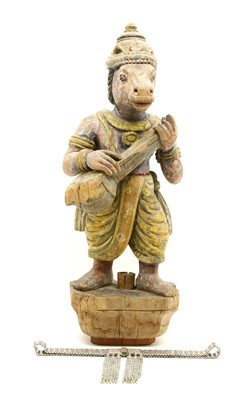 Lot 502 - A carved and painted wooden figure of an Indian deity with horse's head and holding an instrument