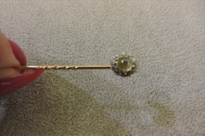 Lot 137 - A cased Edwardian chrysoberyl cat's eye and diamond cluster stick pin/dress stud