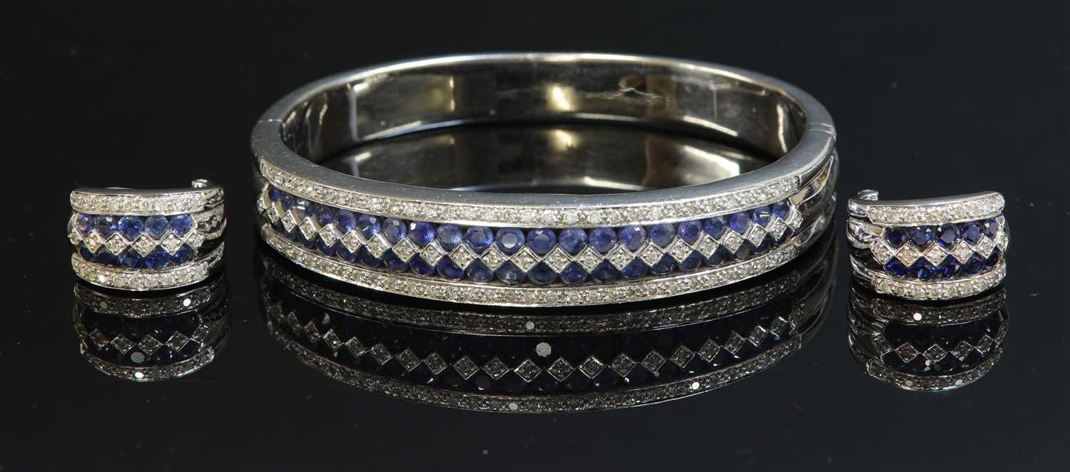 Lot 198 - A white gold sapphire and diamond hinged bangle and earring suite