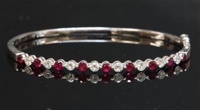 Lot 466 - A white gold ruby and diamond hinged bangle