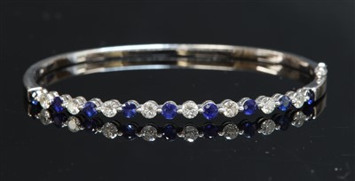 Lot 518 - A white gold sapphire and diamond hinged bangle