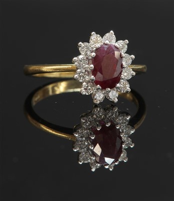 Lot 305 - An 18ct gold ruby and diamond oval cluster ring