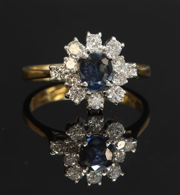 Lot 334 - An 18ct gold sapphire and diamond oval cluster ring