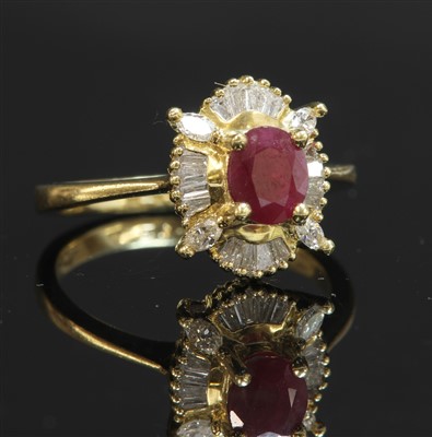 Lot 304 - An 18ct gold ruby and diamond oval cluster ring