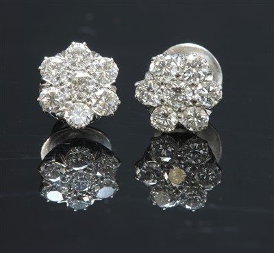 Lot 550 - A pair of white gold diamond set daisy cluster earrings