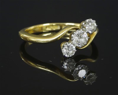 Lot 325 - A gold three stone diamond crossover ring
