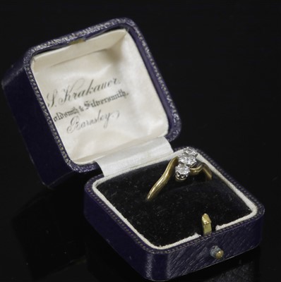 Lot 325 - A gold three stone diamond crossover ring