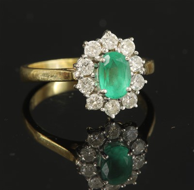 Lot 340 - An 18ct gold emerald and diamond oval cluster ring