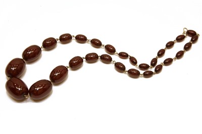 Lot 51 - A single row graduated cherry coloured olive shaped Bakelite bead necklace