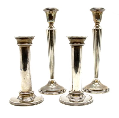 Lot 194 - A pair of white metal candlesticks of column form on circular beadwork foot