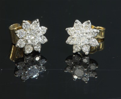 Lot 473 - A pair of gold diamond set flowerhead cluster earrings