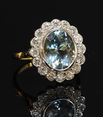 Lot 367 - A gold aquamarine and diamond oval cluster ring