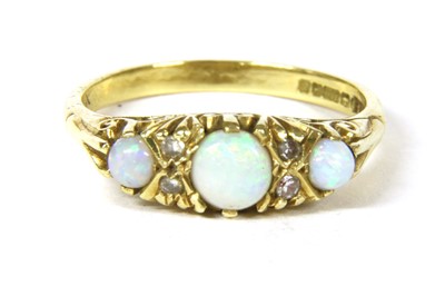 Lot 314 - An 18ct gold three stone opal carved head style ring