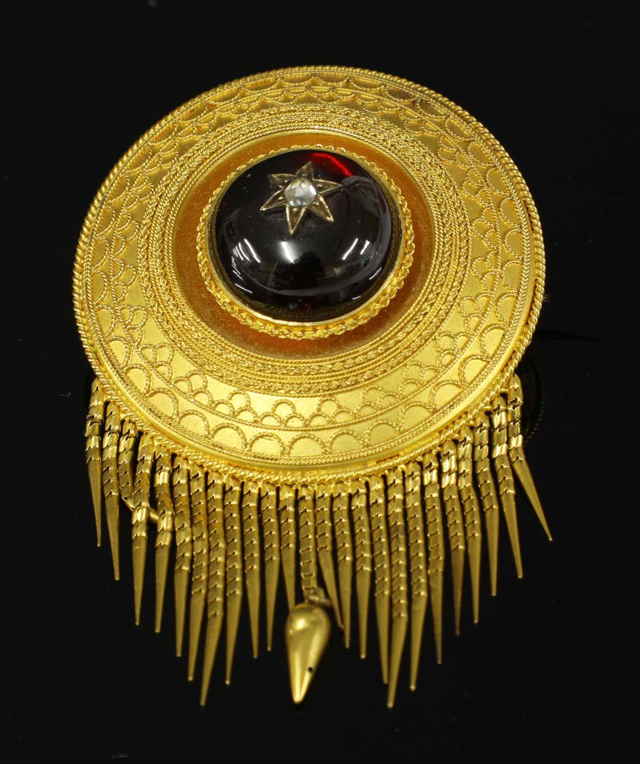 Lot 47 - A Victorian Etruscan Revival circular shield form garnet and diamond brooch, c.1860