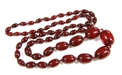 Lot 73 - A single row graduated cherry coloured olive shaped Bakelite bead necklace