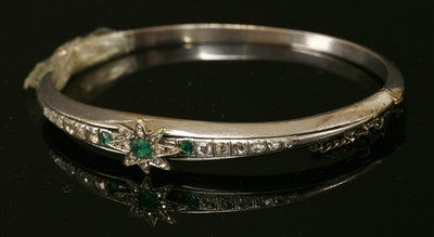 Lot 207 - A Continental emerald and diamond set hinged bangle