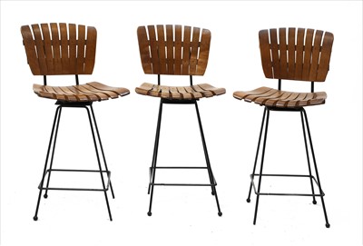 Lot 693 - A set of three teak and steel bar stools