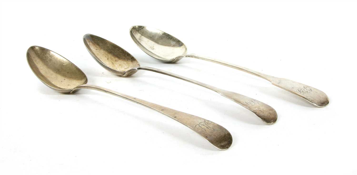 Lot 1148 - Three George III silver basting spoons