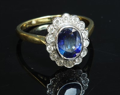 Lot 196 - An 18ct gold sapphire and diamond oval cluster ring