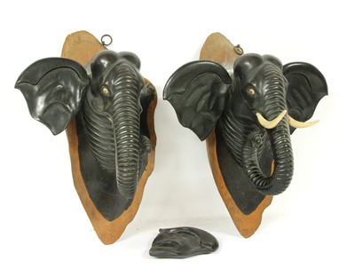 Lot 1343 - A pair of early 20th Century African wall mounted carved macassar ebony elephants