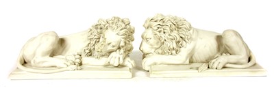 Lot 1390 - Two modern composition stone figures of recumbent lions