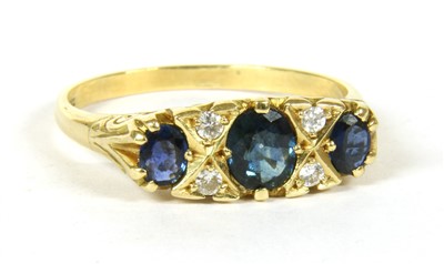 Lot 1065 - An 18ct gold three stone sapphire carved head style ring