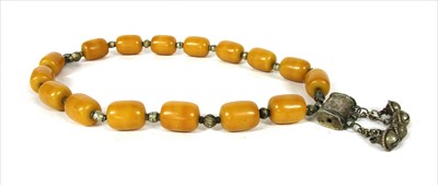 Lot 193 - A tribal amber-coloured bead necklace with silver metal connections