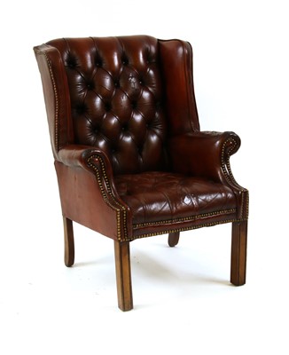 Lot 1707 - A brown leather button back wingback armchair