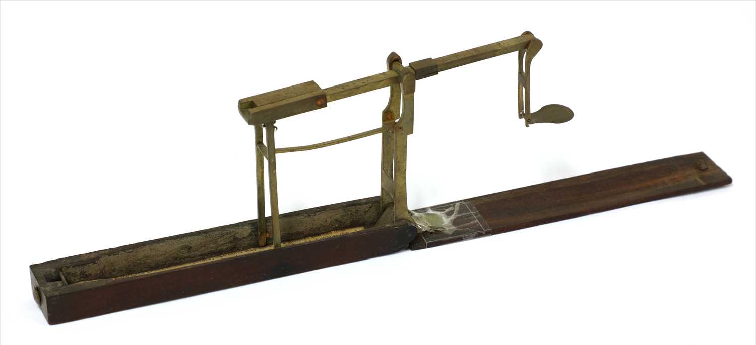 Lot 1057 - A mahogany cased brass folding coin scale