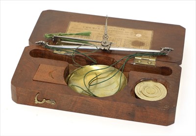 Lot 1063 - A walnut cased brass and steel coin scale