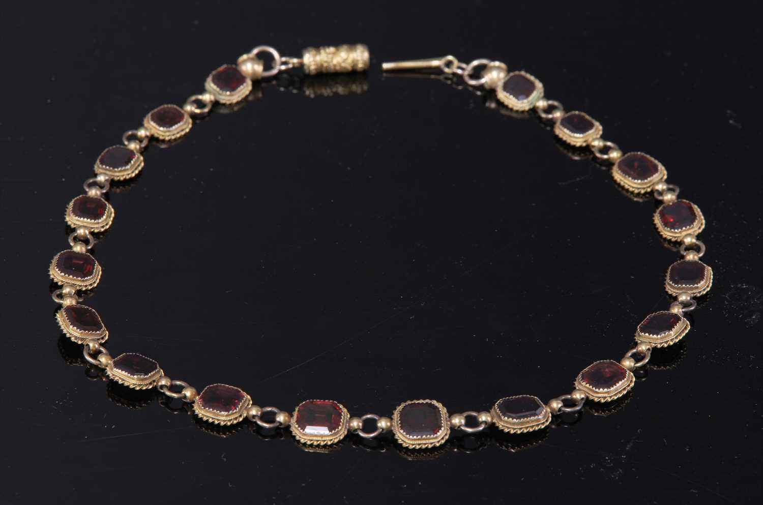 Lot 8 - A gold garnet set rivière necklace