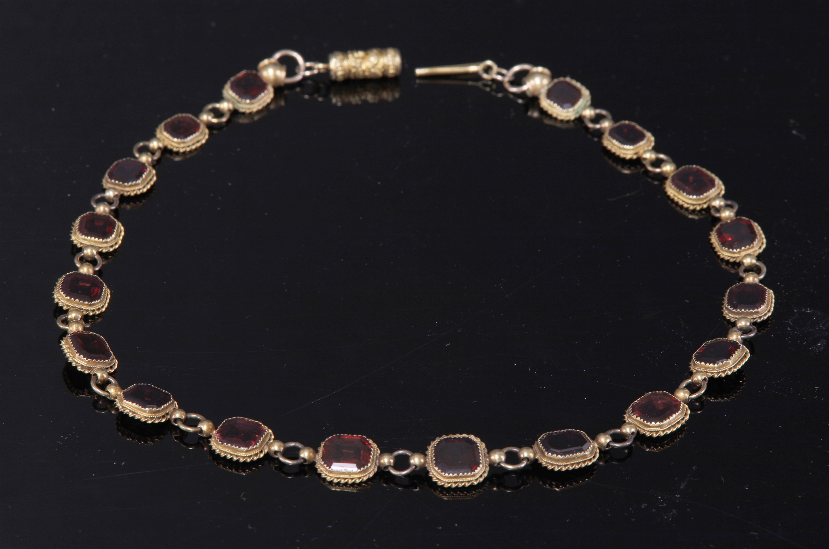Lot 8 - A gold garnet set rivière necklace,