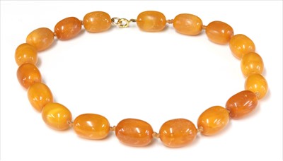 Lot 76 - A single row graduated olive shaped butterscotch amber bead necklace