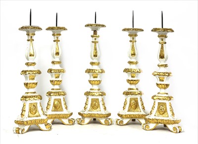 Lot 625 - A set of five Italian carved and painted pine pricket candle stands