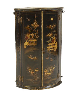 Lot 438 - A lacquered bow front hanging corner cupboard
