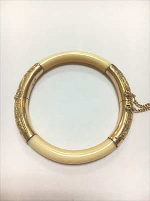 Lot 6 - An early 20th century Chinese carved ivory and gold mounted hinged bangle
