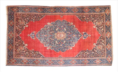 Lot 874 - A large red ground Kashan carpet