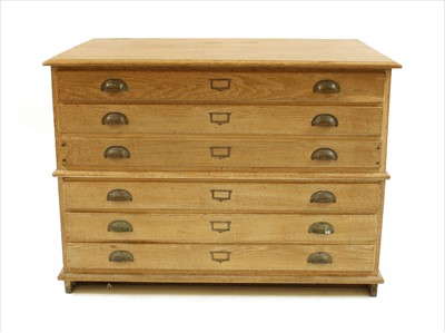 Lot 414 - An early 20th century limed oak two section plans chest of six long drawers