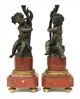 Lot 110 - A pair of French bronze cherub garniture candlesticks