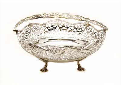 Lot 132 - A large silver pierced circular bread basket having swing handle and raised on shell feet