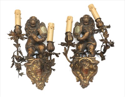Lot 670 - A pair of carved wood and giltwood armorial wall lights