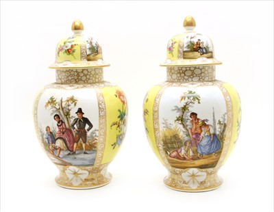 Lot 409 - A pair of hand painted and gilt heightened Continental porcelain vases and covers