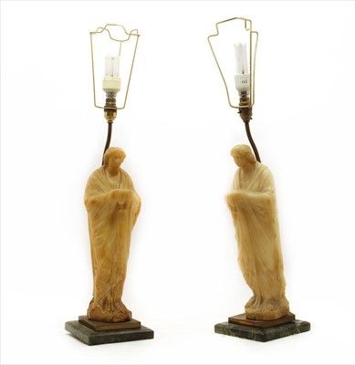 Lot 350 - A pair of onyx figural table lamps raised on marble plinths