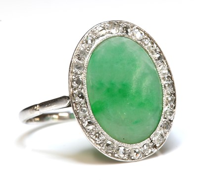 Lot 113 - An Art Deco white gold jade and diamond oval cluster ring