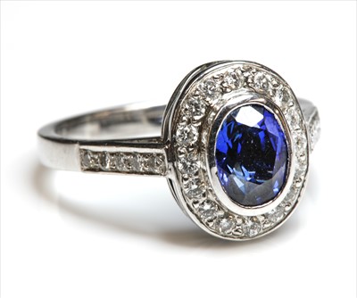 Lot 228 - An 18ct white gold sapphire and diamond oval cluster ring